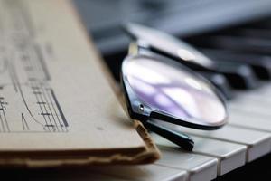 Sheet music and eyeglasses on the piano keys photo