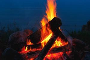 Closeup shot of outdoors campfire brightly burning at night. photo