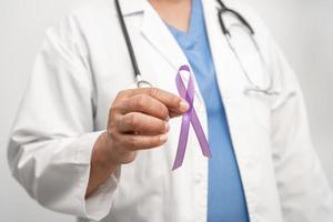 Asian woman doctor with purple ribbon, sign of Alzheimer disease day, Pancreatic cancer, Epilepsy, Lupus. photo