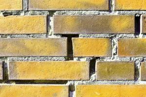 Detailed view at a colorful old and weathered brick wall texture as a panoramic background. photo