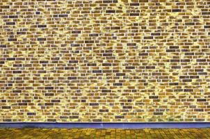 Detailed view at a colorful old and weathered brick wall texture as a panoramic background. photo