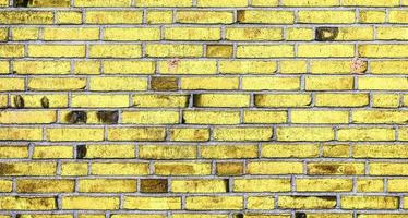 Detailed view at a colorful old and weathered brick wall texture as a panoramic background. photo