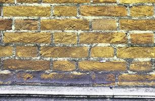 Detailed view at a colorful old and weathered brick wall texture as a panoramic background. photo
