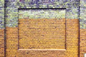 Detailed view at a colorful old and weathered brick wall texture as a panoramic background. photo