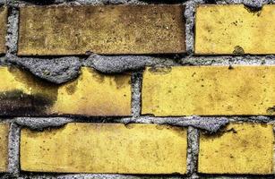 Detailed view at a colorful old and weathered brick wall texture as a panoramic background. photo