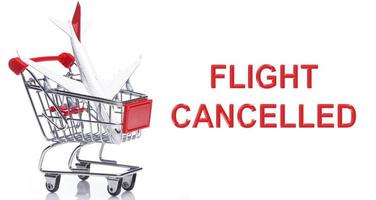 Airplane in a shopping trolley with a message - FLIGHT CANCELLED. photo
