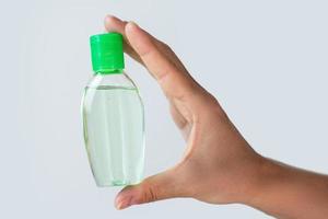 Hand with a small bottle of hand sanitizer photo