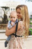 Beautiful mother with her baby son on the street photo