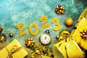 Happy new year 2023. Top view of golden Numbers 2023 with christmas ornament and antique clock. New Years eve celebration concept background photo