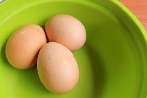 tres huevos de gallina aislados de fondo blanco y verde. foto