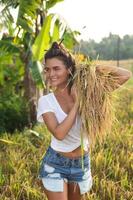 mujer agricultora feliz durante la cosecha en el campo de arroz