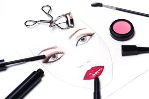 tabla de caras y diferentes objetos de maquillaje y cosméticos foto