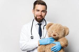 pediatra profesional con un oso de peluche en las manos foto