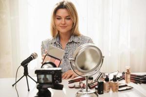 Beauty blogger with blush palette recording video for her followers photo