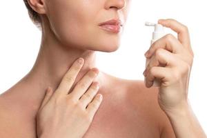 Woman is using spray with analgesic for sore throat relief photo