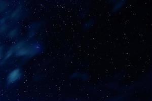 cielo nocturno con estrellas y nubes en movimiento foto