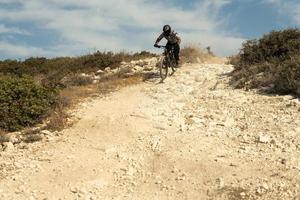 Professional bike rider during downhill ride on his bicycle photo