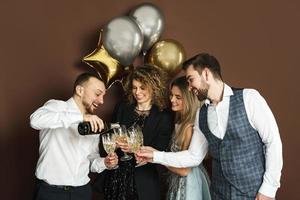 Well dressed party people celebrating  holiday or event and drinking sparkling wine photo