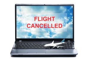 Toy airplane on a laptop with a message - FLIGHT CANCELLED photo