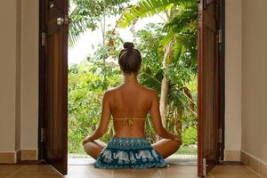 Young woman sitting on the doorstep of her bungalow photo