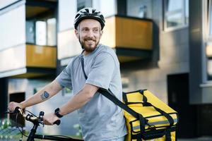 mensajería urgente de entrega de alimentos con bolsa aislada de pie con bicicleta. foto