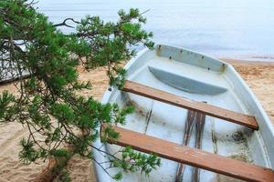 Closeup shot of abandoned fishing boat on sandy beach. photo