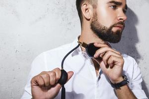 Handsome bearded man is using atomizer nozzle with perfume photo