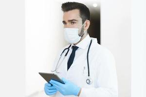 Young and confident doctor is using tablet pc photo