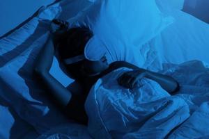 mujer durmiendo con un antifaz para dormir en los ojos foto