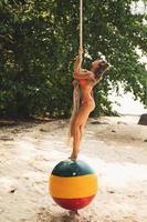 Happy woman on swings made from old buoy on the beach photo