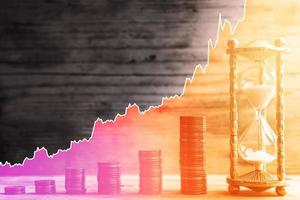 Hourglass, euro coins and rising sparkline chart. Concept of time value of money and investment. photo