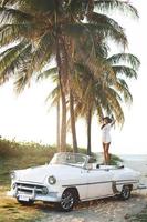 Happy young woman and retro convertible car photo