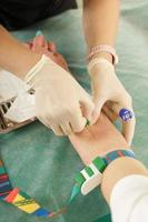 Enfermera recogiendo muestra de sangre del paciente para prueba o donación. foto