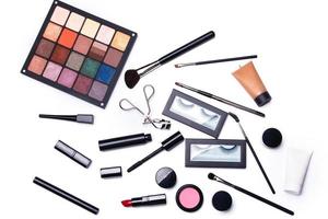 Different makeup objects and cosmetics on white photo