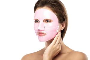 Young beautiful woman with rubber facial mask on her face photo