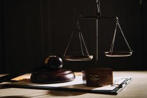 Justice and law concept.Male judge in a courtroom with the gavel, working with, computer and docking keyboard, eyeglasses, on table in morning light photo