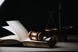 Justice and law concept.Male judge in a courtroom with the gavel, working with, computer and docking keyboard, eyeglasses, on table in morning light photo