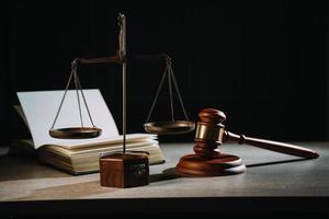Justice and law concept.Male judge in a courtroom with the gavel, working with, computer and docking keyboard, eyeglasses, on table in morning light photo