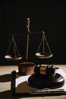 Justice and law concept.Male judge in a courtroom with the gavel, working with, computer and docking keyboard, eyeglasses, on table in morning light photo