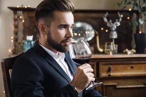 Handsome bearded man with a glass of red wine photo