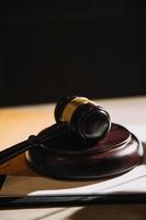 Justice and law concept.Male judge in a courtroom with the gavel, working with, computer and docking keyboard, eyeglasses, on table in morning light photo