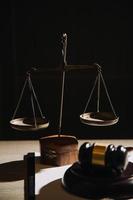 Justice and law concept.Male judge in a courtroom with the gavel, working with, computer and docking keyboard, eyeglasses, on table in morning light photo