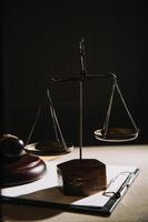 Justice and law concept.Male judge in a courtroom with the gavel, working with, computer and docking keyboard, eyeglasses, on table in morning light photo