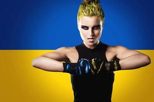 Strong woman fighter with a Ukrainian flag on background photo