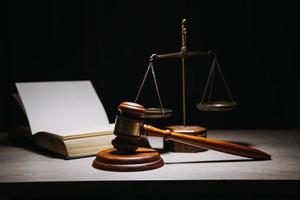 Justice and law concept.Male judge in a courtroom with the gavel, working with, computer and docking keyboard, eyeglasses, on table in morning light photo