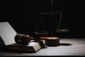 Justice and law concept.Male judge in a courtroom with the gavel, working with, computer and docking keyboard, eyeglasses, on table in morning light photo