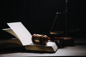 Justice and law concept.Male judge in a courtroom with the gavel, working with, computer and docking keyboard, eyeglasses, on table in morning light photo