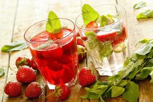 Glass of Refreshing drink with strawberry on wooden table photo