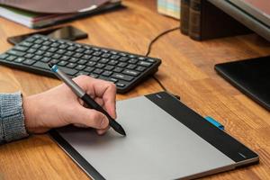 Closeup of male hands during using a graphic tablet photo