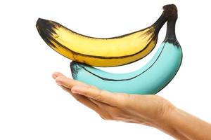 Female hand and creatively decorated colorful bananas photo